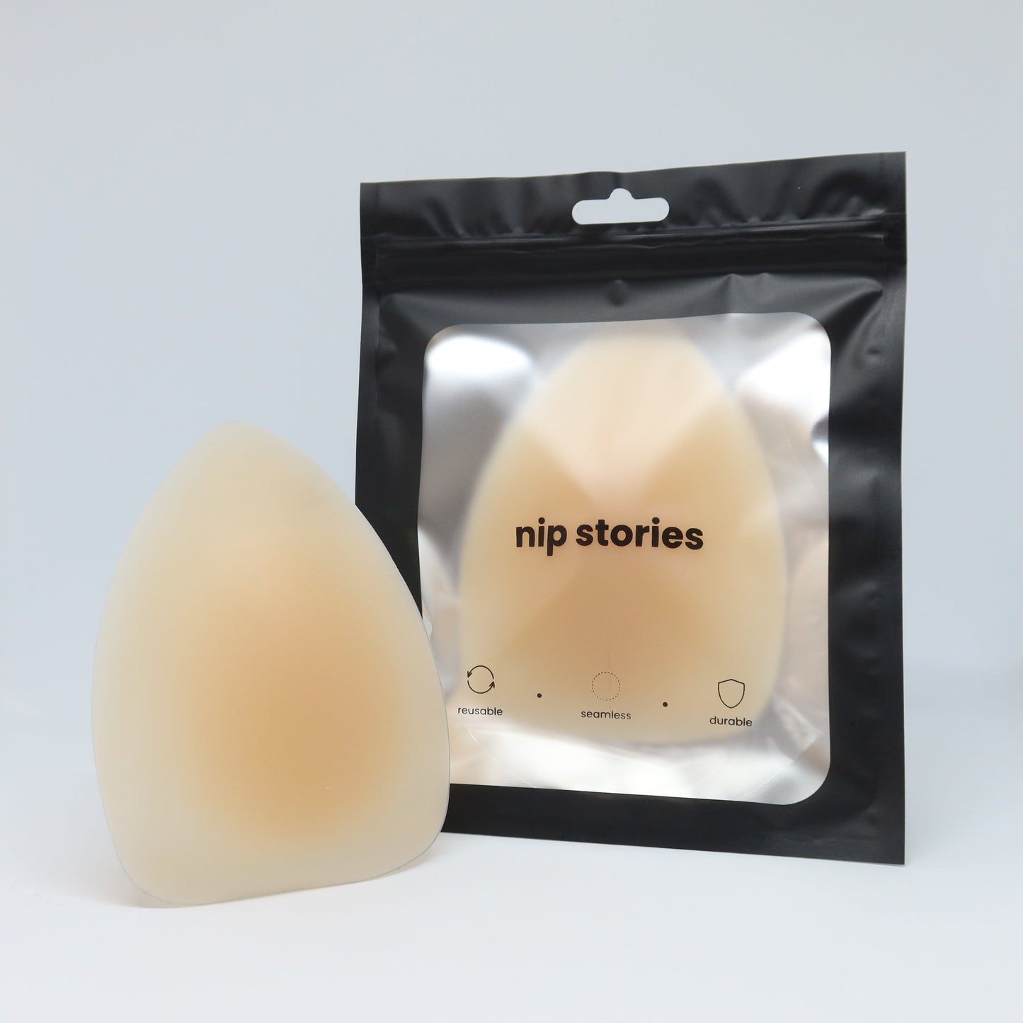 Nip story triangle adhesive nipple covers with packaging on a light gray background
